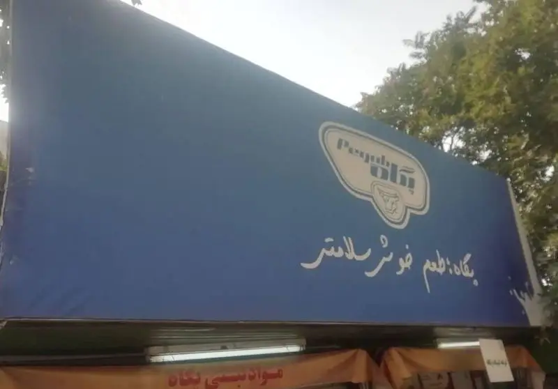تصویری از تابلوی آبی رنگ غرفه فروش لبنیات پگاه با لوگوی شرکت و شعار "طعم خوشتر، سلامت‌تر"، بیانگر تعهد پگاه به کیفیت.