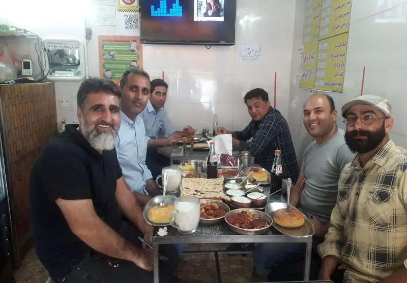 مشتریان در رستوران دیزی سنگی آراز (سید) مشغول لذت بردن از دیزی خوشمزه، نان تازه و دوغ سنتی ایرانی هستند. فضایی گرم و دوستانه.