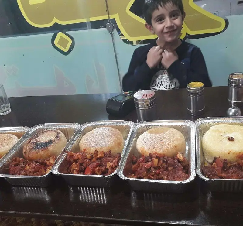 کودکی شاد و دیزی‌های سنگی آراز (سید) با نان داغ. غذای سنتی و لذیذ ایرانی در بسته بندی آماده برای سرو.