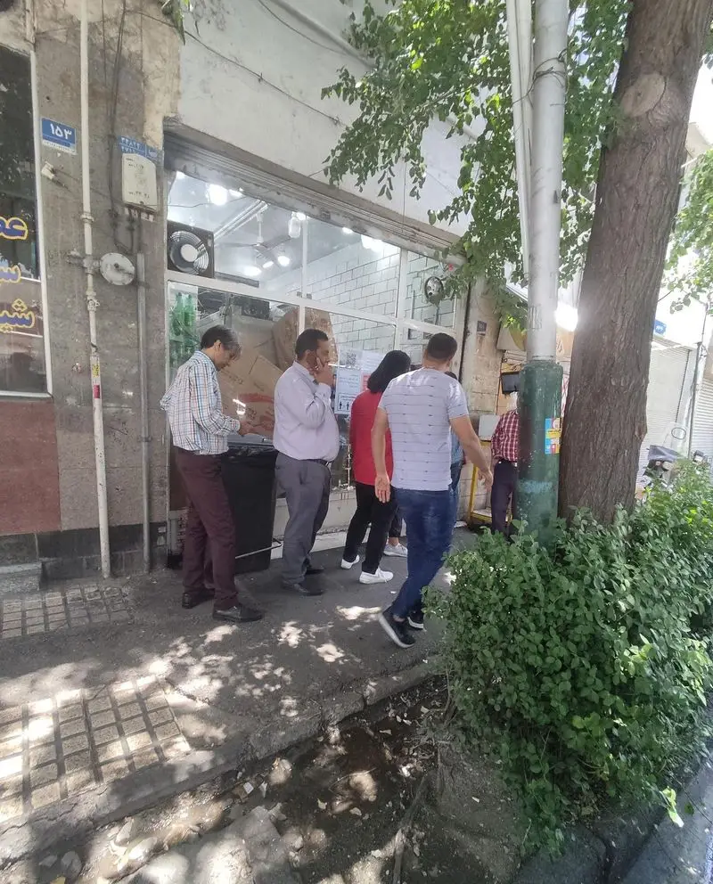 تصویری از نمای خارجی ساندویچ موسیو در خیابان، با حضور مشتریان و رهگذران، مکانی برای سرو ساندویچ‌های محبوب.