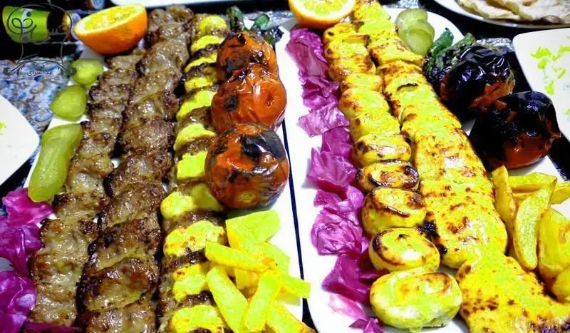 انواع کباب اصیل ایرانی شامل جوجه کباب، کباب برگ و کوبیده با گوجه فرنگی، سیب زمینی سرخ کرده و دورچین لذیذ از تهیه غذا حس خوب.