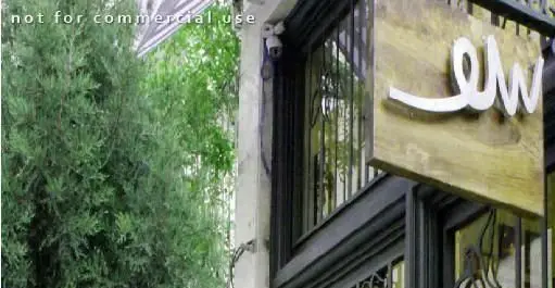 تصویری از نمای بیرونی کافی شاپ سو یامی، با تابلو چوبی خاص و لوگوی سفید "سو"، احاطه شده با فضای سبز و پنجره‌های شیشه‌ای.