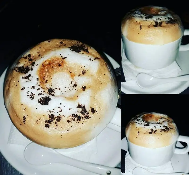 قهوه لاته یا کاپوچینوی فوم‌دار و دلپذیر با تزیین پودر شکلات در کافه رستوران برج آزادی تهران. لحظاتی گرم و لذت‌بخش.