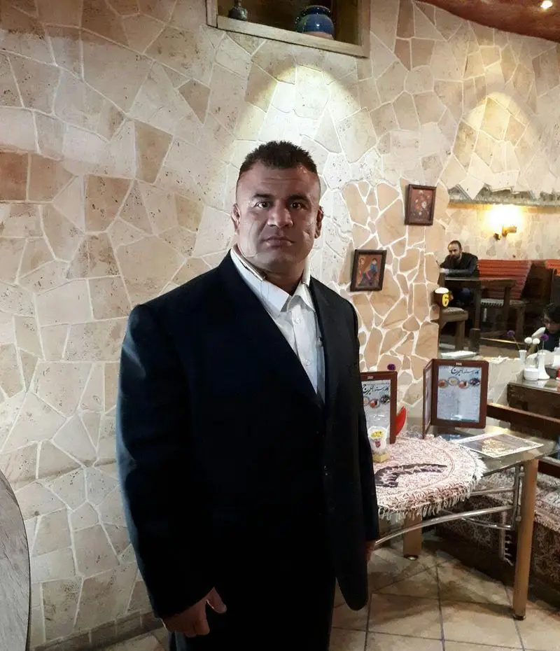 مردی با کت و شلوار در فضای دلنشین کافه رستوران برج آزادی تهران. تجربه غذایی بی‌نظیر با دکوراسیون سنگی جذاب.