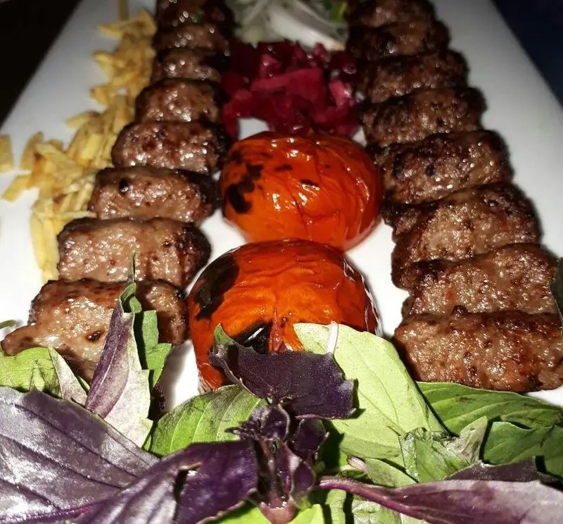 کباب کوبیده لذیذ به همراه گوجه کبابی، سبزی تازه، ترشی و سیب‌زمینی سرخ کرده از منوی کافه رستوران برج آزادی.