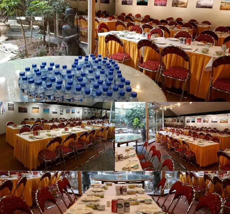 کافه رستوران برج آزادی: چیدمان شیک میزها با رومیزی زرد و صندلی قرمز، فضای داخلی دنج و باغ سرسبز برای میزبانی مراسم.