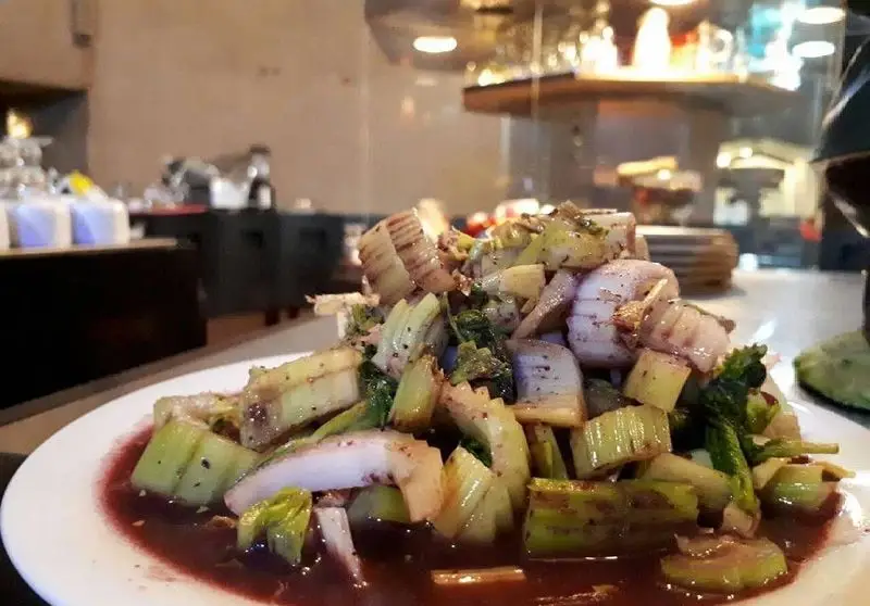 غذای لذیذ و سالم کافه رستوران برج آزادی: سالاد سبزیجات تازه شامل ساقه کرفس و پیاز در سس قرمز، انتخابی خوشمزه برای مشتریان.