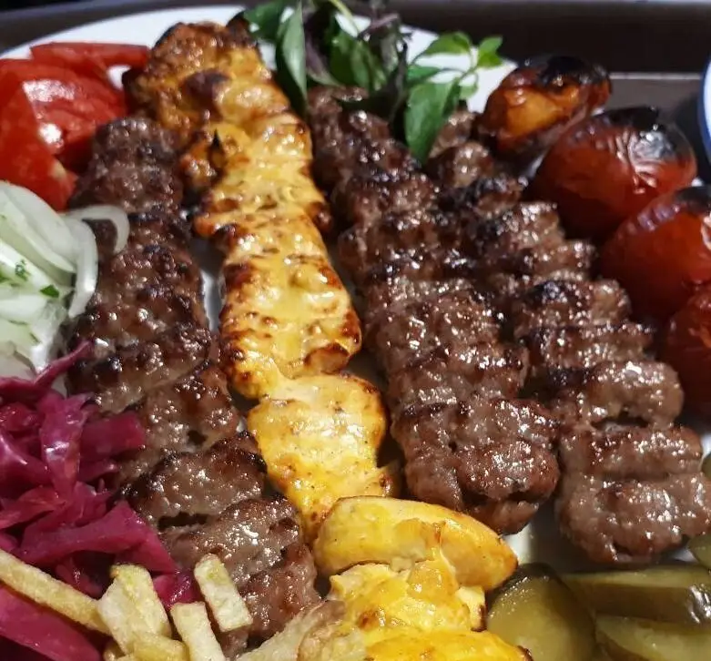 منوی کافه رستوران برج آزادی: سینی کباب میکس جوجه و کوبیده با گوجه کبابی، پیاز، مخلفات تازه و سیب زمینی سرخ کرده. غذای ایرانی خوشمزه.