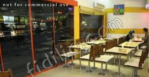 فضای داخلی دلپذیر فست فود کلیز در شب، با میز و صندلی‌های مدرن و محیطی آرام برای صرف غذای خانوادگی و دوستانه.