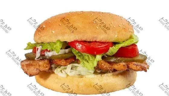 ساندویچ فیله مرغ خوشمزه کلیز با نان کنجدی، کاهو تازه، گوجه، پیاز و خیارشور، ارائه شده در فست فود کلیز.