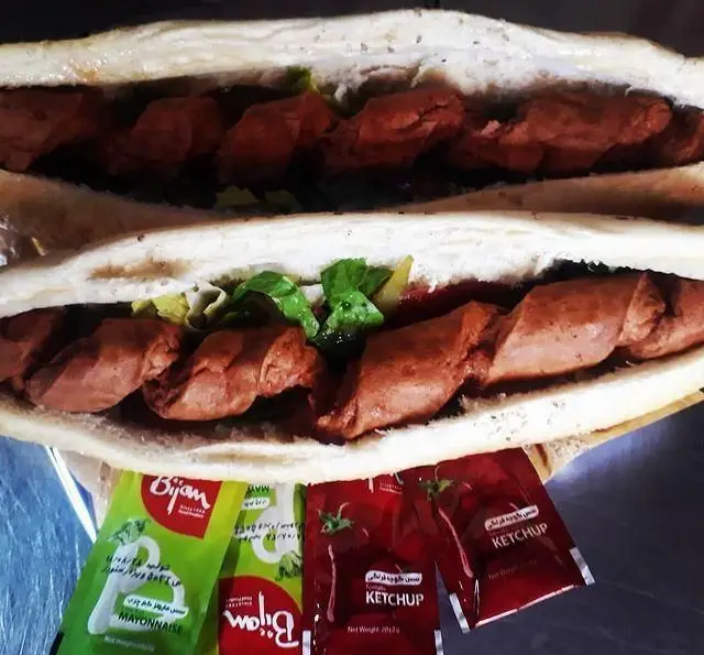 تصویر ساندویچ‌های سوسیس پیچ فست فود 1+5، با نان باگت تازه، کاهو، خیارشور و سس کچاپ و مایونز بیژن برای سفارش آنلاین.