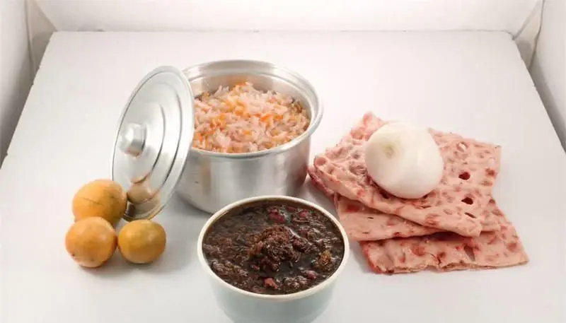 وعده غذای سنتی و اصیل ایرانی از رستوران علاالدین: شامل پلو خوش‌رنگ، خورش غلیظ، نان محلی، پیاز و لیمو تازه. تجربه‌ای لذت‌بخش.