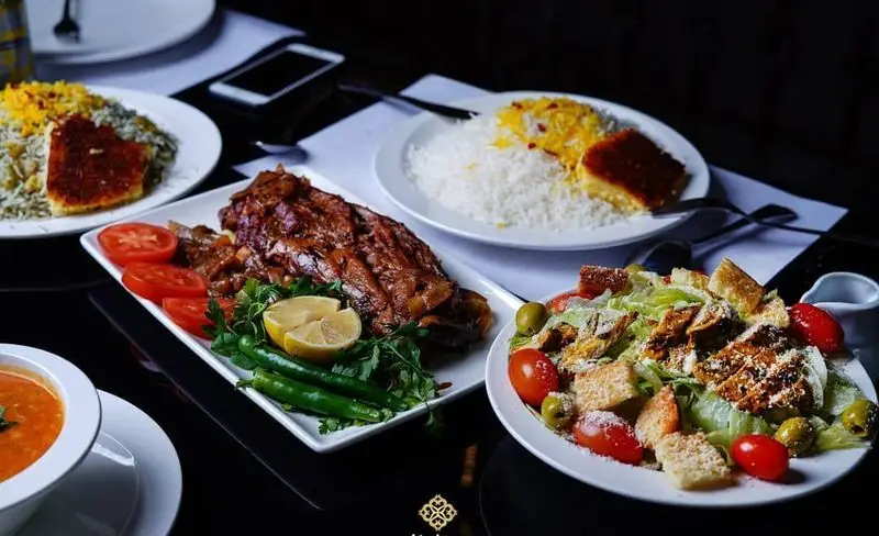 نمایی از منوی متنوع رستوران ایرانی شاندیز ماهان رویال شامل غذای اصلی گوشت، پلو با ته دیگ، سوپ و سالاد سزار. بهترین غذای سنتی ایران را تجربه کنید.