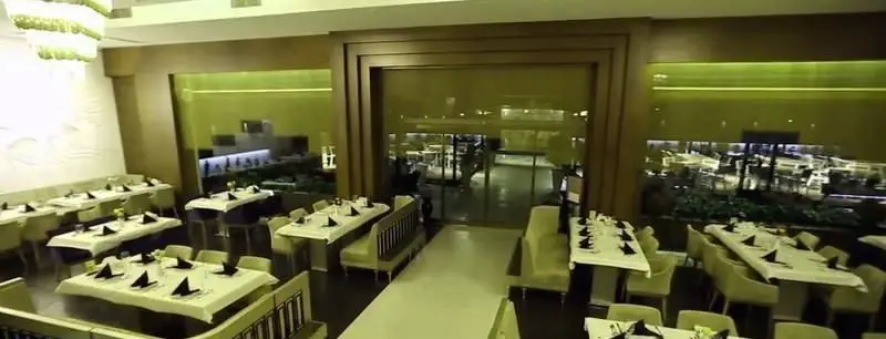 فضای داخلی شیک و لوکس رستوران ایرانی شاندیز ماهان رویال با میزهای چیدمان شده آماده پذیرایی از مهمانان. دکوراسیون مدرن و نورپردازی خاص.