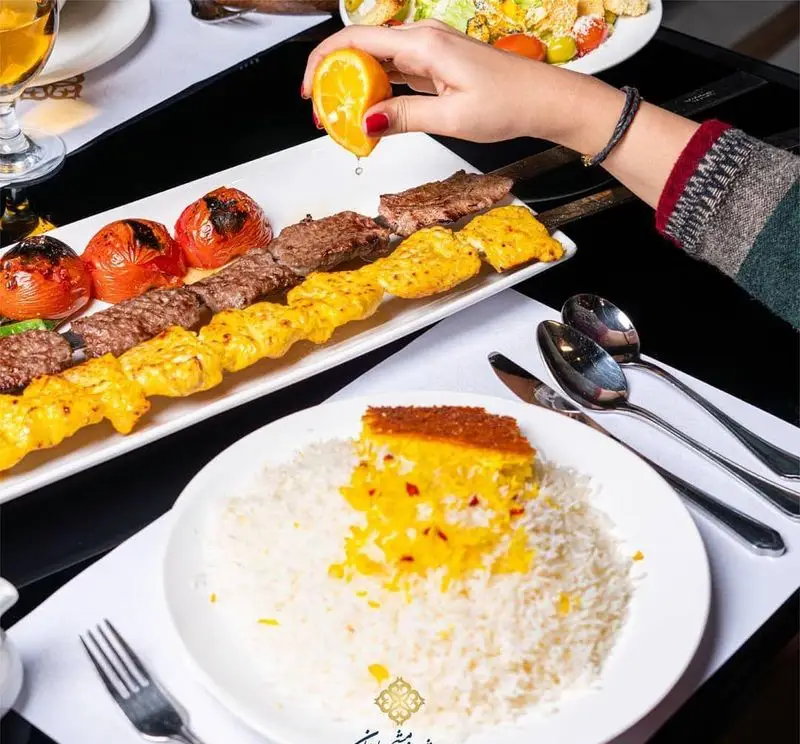 کباب کوبیده و جوجه کباب لذیذ با ته چین و پلو زعفرانی در رستوران ایرانی شاندیز ماهان رویال. تجربه‌ای بی‌نظیر از غذای اصیل ایرانی.