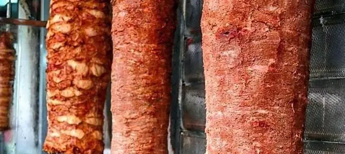 سیخ‌های دنر کباب ترکی اصیل گوشت و مرغ آبدار و خوشمزه، آماده برای برش در رستوران فست فود ترک دنر با بهترین کیفیت.