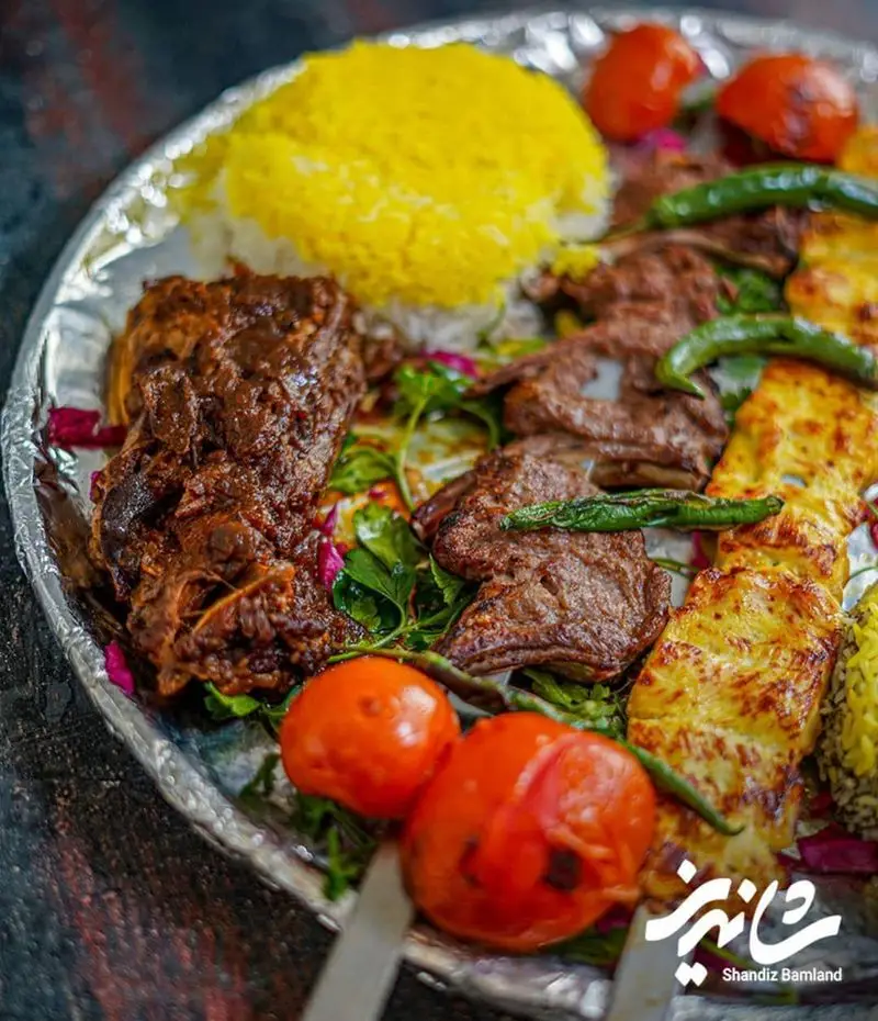 سینی غذای رستوران شاندیز شامل انواع کباب، برنج زعفرانی، ماهیچه و گوجه کبابی. تجربه طعم اصیل ایرانی با کیفیت بی‌نظیر.