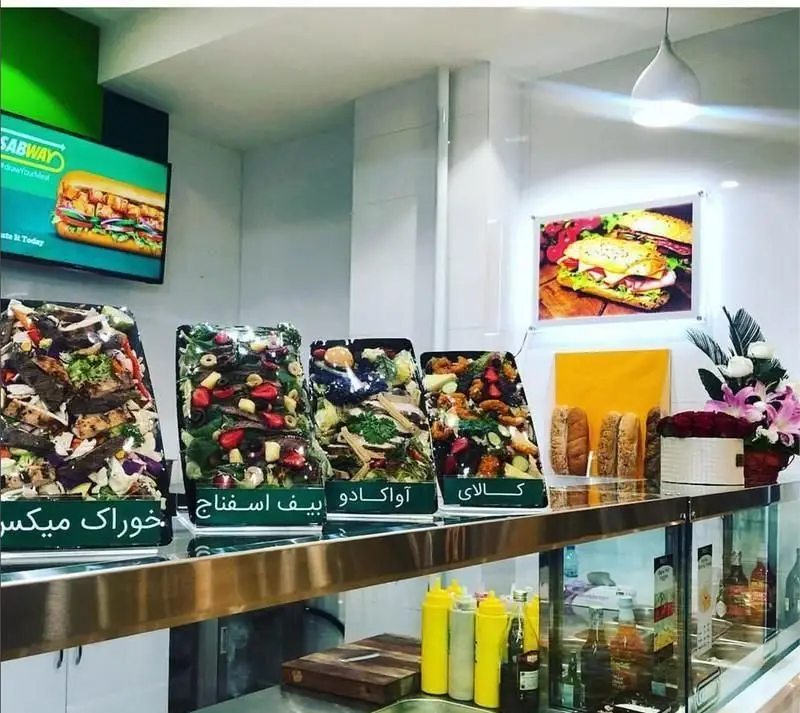 نمای داخلی فست فود ساب وی: نمایشگر ساندویچ، پیشخوان با انواع سالاد، مواد اولیه تازه و نان برای ساندویچ و سالاد سفارشی.