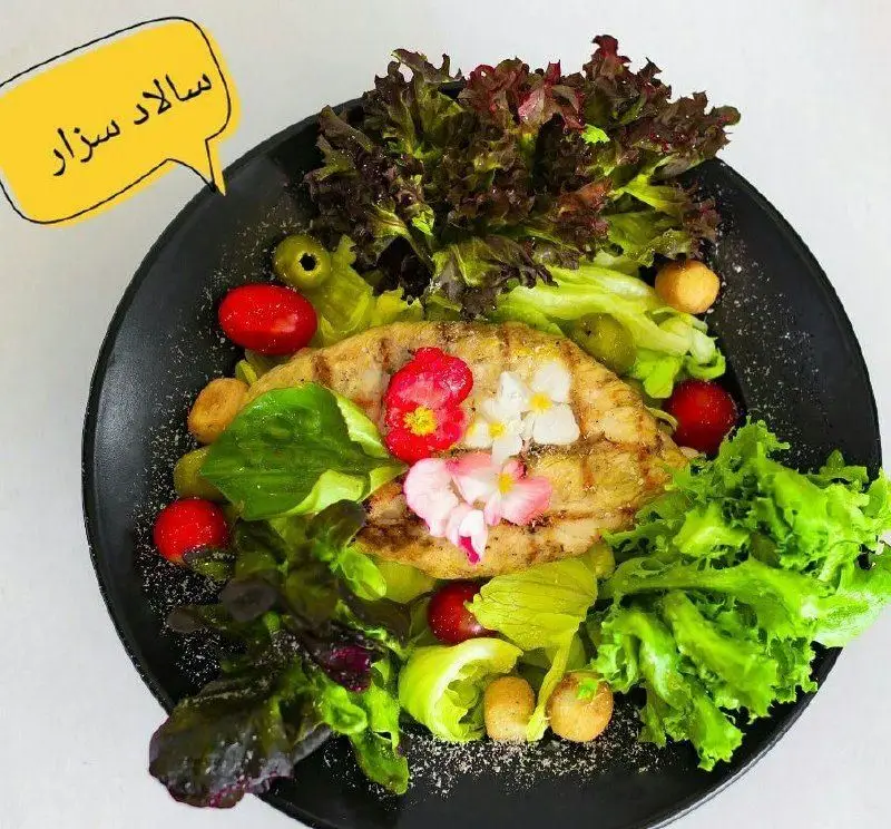 سالاد سزار سوخاری مهدی با مرغ گریل، کاهو تازه، گوجه، کروتون و گل‌های خوراکی. انتخابی عالی برای منوی رستوران.