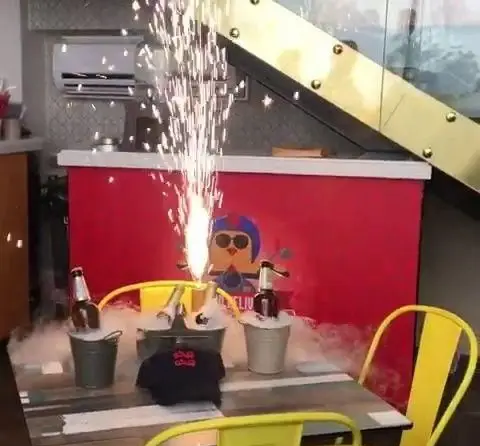 فضایی جذاب و خاص در رستوران سوخاری مهدی: میز با سرو نوشیدنی‌های خنک در سطل‌های فلزی، همراه با آبشار سرد و بخار هیجان‌انگیز.