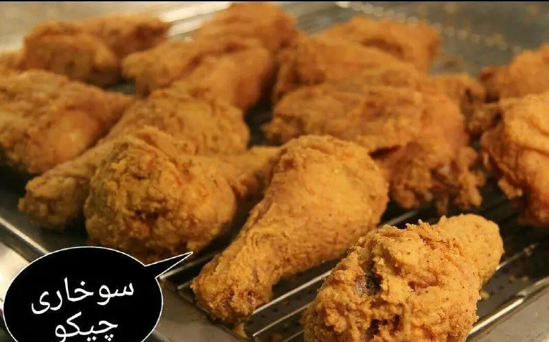 تصویر اشتهاآور از انبوه مرغ سوخاری کرانچی و طلایی روی توری، آماده ارائه در بهترین فست فود سوخاری مهدی. طعمی به یاد ماندنی.
