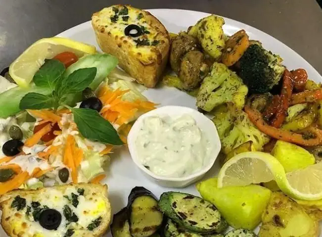 بشقاب میکس رنگارنگ کافه وفست فود سیوان: سبزیجات کبابی (کدو، بادمجان)، سبزیجات تنوری، سالاد تازه، نان پنیری و دیپ. ایده‌آل برای یک وعده سالم.