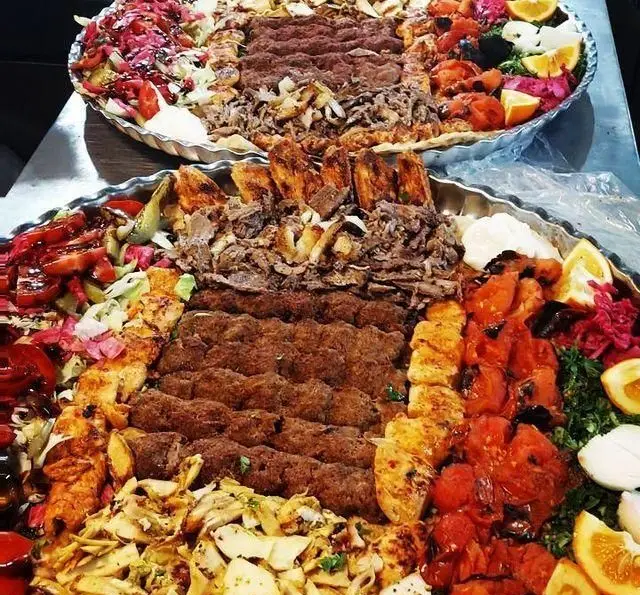 سینی‌های بزرگ کباب ابوعلی با مجموعه‌ای از کباب کوبیده، جوجه کباب، شاورما، گوجه کبابی و انواع دورچین‌های تازه و اشتهاآور.