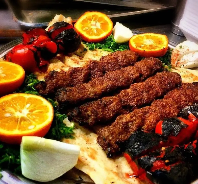 کباب کوبیده خوشمزه ابوعلی، همراه با گوجه کبابی آبدار، نان داغ و مخلفات تازه. لذت غذای اصیل ایرانی.