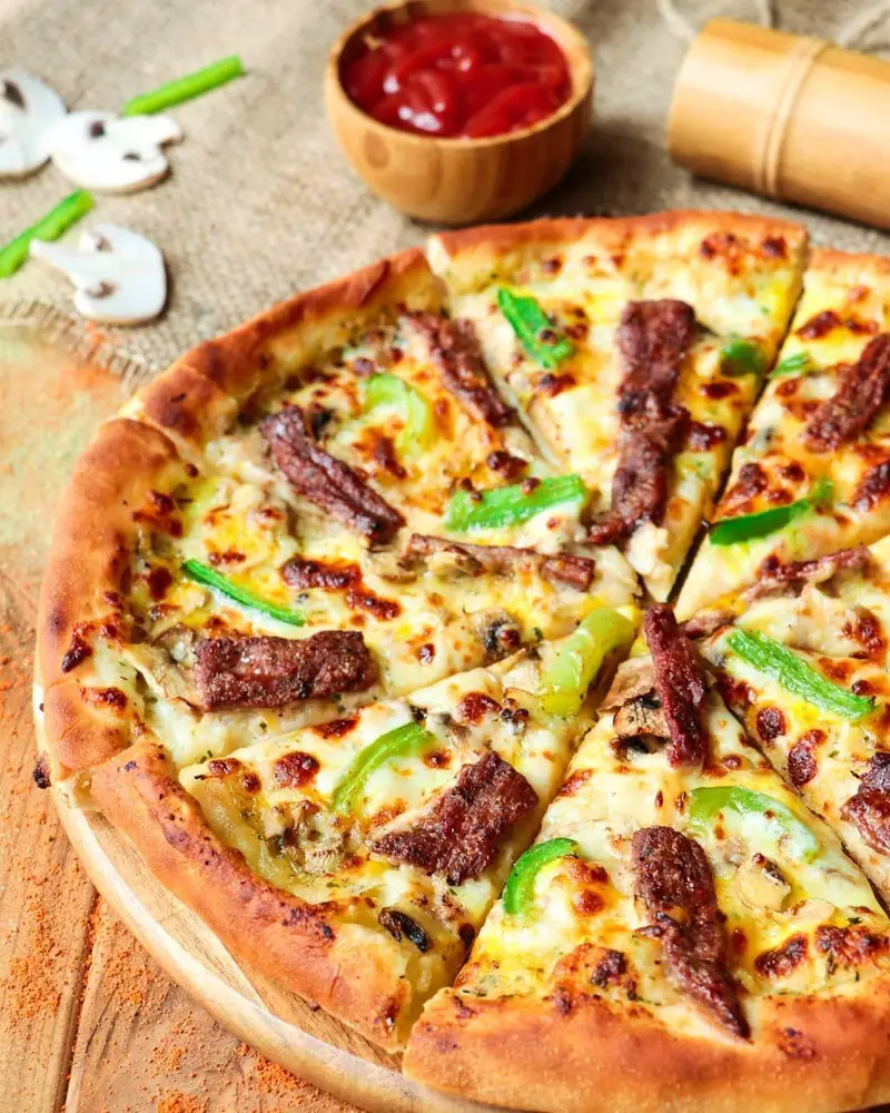 پیتزای ویژه و خوشمزه فست فود شیلا با ترکیب عالی تکه‌های گوشت طعم‌دار، قارچ تازه و فلفل دلمه‌ای سبز، مناسب برای دورهمی و سفارش آنلاین.