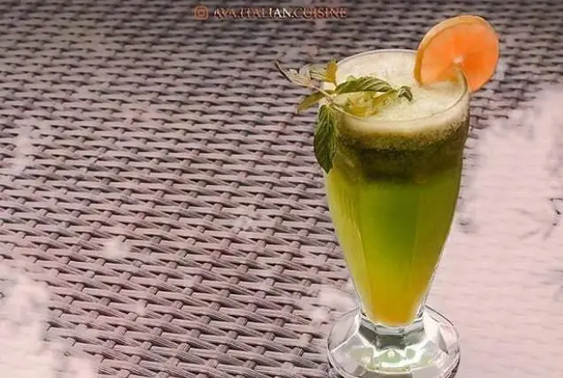 نوشیدنی سبز خنک و دلپذیر با برگ‌های نعناع تازه و برش پرتقال، مناسب برای همراهی با پیتزاهای لذیذ در پیتزا اوا.