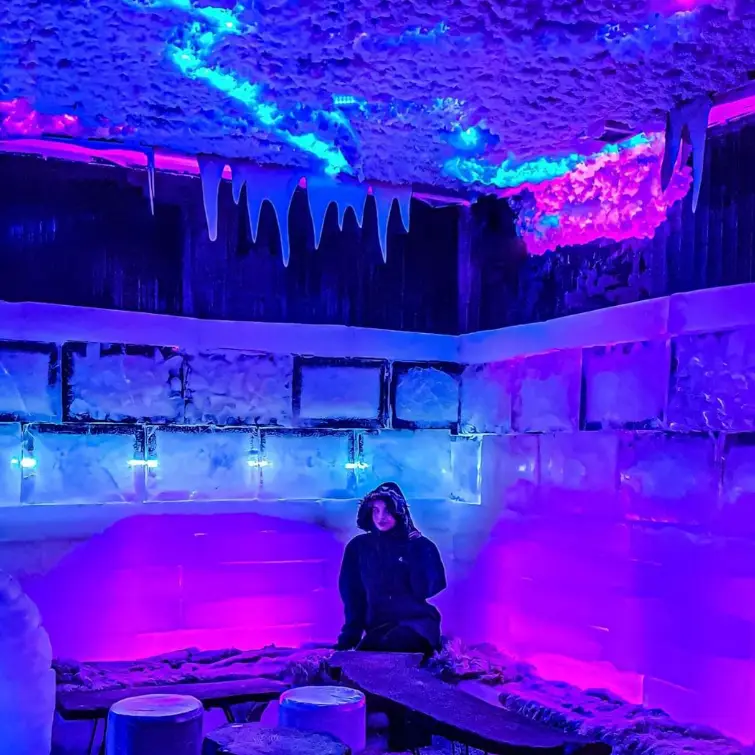 فضای داخلی خیره کننده کافه فصل یخ با دیوارها و دکور یخی، نورپردازی خاص آبی و بنفش و سقف پوشیده از قندیل. تجربه ای منحصر به فرد.