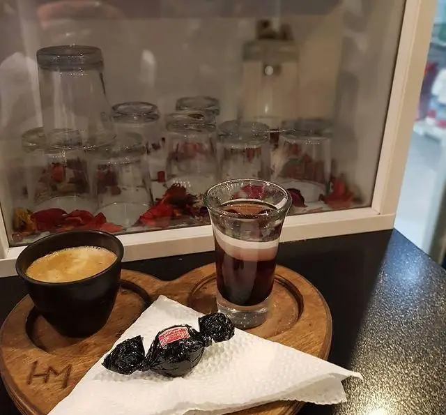 نمایی از قهوه غلیظ، شات لایه‌ای و شیرینی سنتی در کافه و سفره خانه تیام. تجربه‌ای دلپذیر از نوشیدنی‌های ویژه و خوراکی‌های لذیذ.