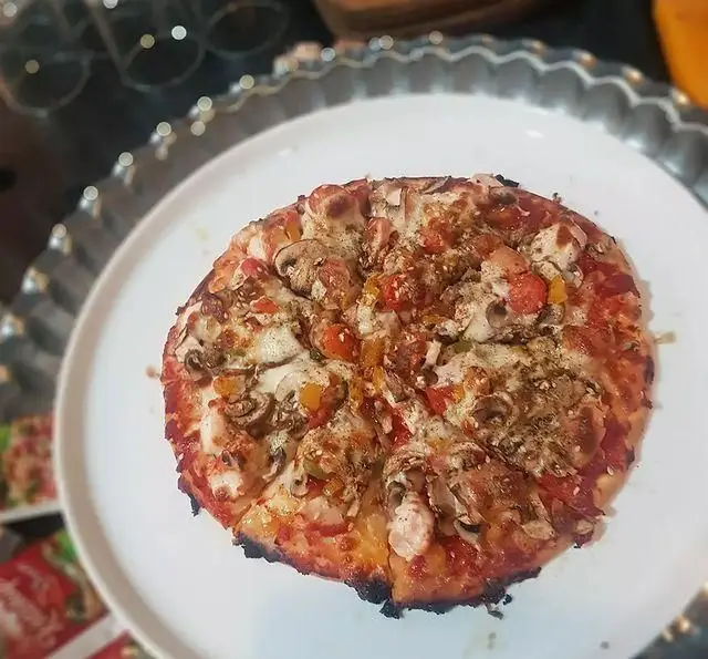 پیتزا مخصوص کافه و سفره خانه تیام با قارچ، فلفل دلمه رنگی و مرغ، پخته شده با پنیر و ادویه‌جات معطر.