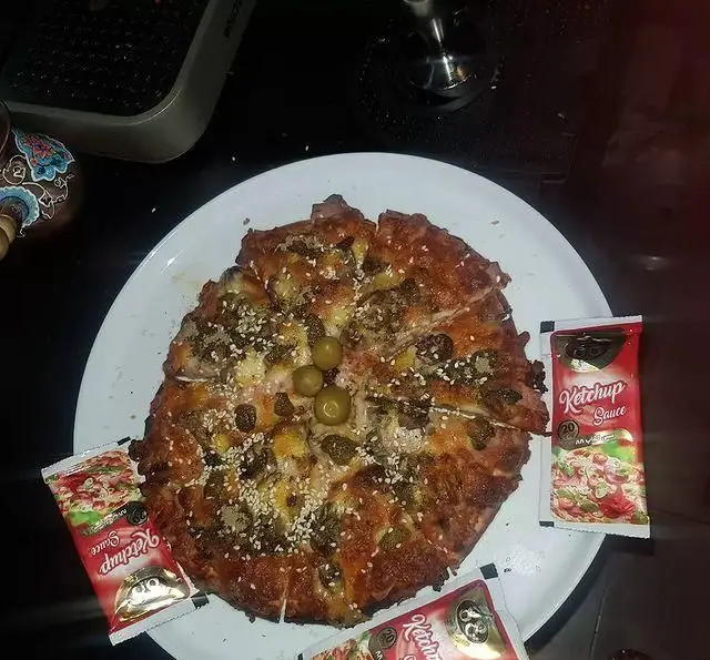 پیتزا خوشمزه و تازه کافه تیام با زیتون، کنجد و سس کچاپ، آماده سرو در سفره خانه تیام. غذای گرم و لذیذ.