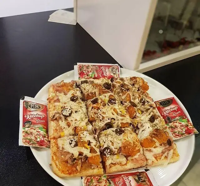 پیتزا مستطیلی خوشمزه و تازه کافه و سفره خانه تیام، با پنیر و زیتون و سس کچاپ 88. بهترین انتخاب برای فست فود.