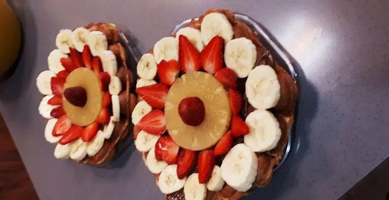 وافل میوه ای تازه و خوشمزه بستنی مکلی نیروهوایی با موز، توت فرنگی، آناناس و سس شکلات، یک دسر دلپذیر و جذاب.