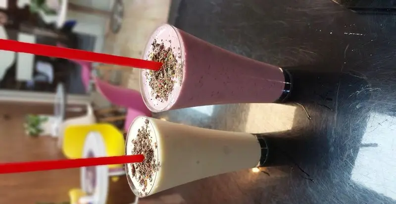 نوشیدنی‌های تازه و خنک: دو لیوان اسموتی/میلکشیک با طعم توت فرنگی و وانیل، با تزیین شکلات در بستنی مکلی نیروهوایی.