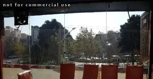 منظره دلپذیر و روشن از فست فود هات سان از پنجره‌های بزرگ، با دید به پارک سرسبز، خیابان و ساختمان‌های شهر. مکانی عالی برای صرف غذا.