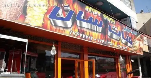 نمای بیرونی فست فود هات سان (Hot Sun) با تابلوی درخشان و لوگوی برجسته، نمایش ساندویچ و غذاهای آماده، به همراه شماره های تماس.