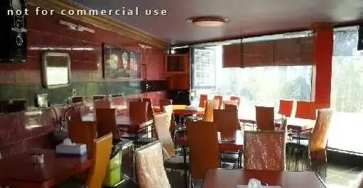 تصویری از محیط داخلی فست فود هات سان با چیدمان تمیز و دکوراسیون مدرن، شامل میز و صندلی‌های متعدد، مناسب برای صرف غذا و دورهمی.