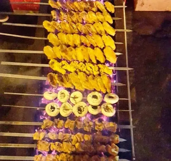 جوجه کباب لذیذ عمو امید، کباب قارچ و کباب گوشت تازه بر روی منقل ذغالی داغ در حال پخت برای سرو در رستوران عمو امید.