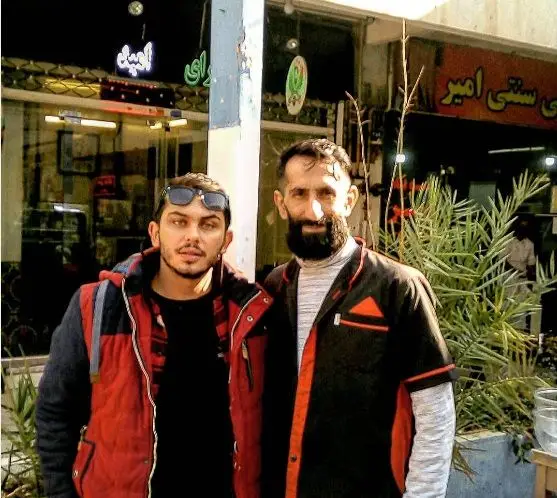 "عمو امید" و یک جوان در مقابل کسب و کار سنتی خود، مغازه‌ای با تابلوهای "امید" و "سنتی امیر" ایستاده‌اند.