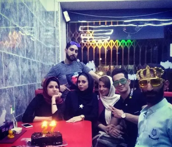 مشتریان شاد در حال جشن تولد 27 سالگی در محیط دلنشین کافه و رستوران عمو امید، با کیک و شادی گروهی.