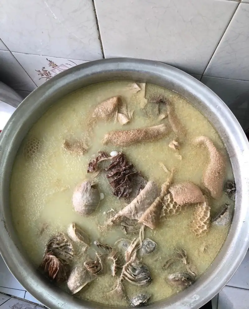 دیگ بزرگ پر از سیرابی پخته شده با آبگوشت لذیذ در طباخی منوچهر، غذای سنتی و گرمابخش ایرانی آماده سرو.