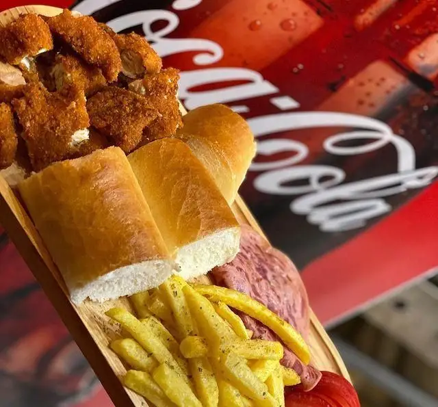 سینی مزه پیتزا چوکوتا شامل مرغ سوخاری، سیب زمینی سرخ کرده، نان تازه و مخلفات با پس‌زمینه کوکاکولا، انتخابی خوشمزه.