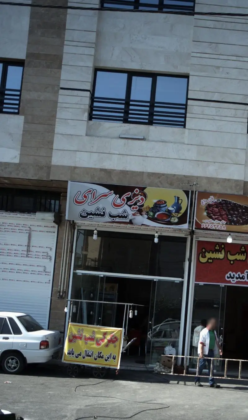 نمای بیرونی دیزی سرای شب نشین، رستوران سنتی ایرانی همراه با تابلوهای نان داغ و جگرکی شب نشین و ماشین در خیابان