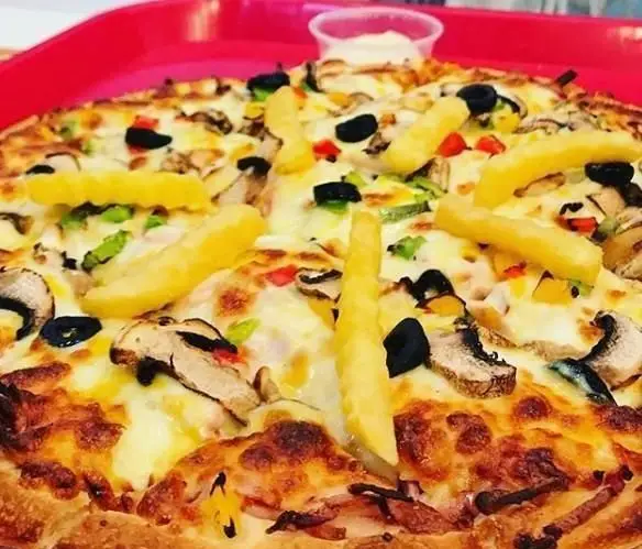 پیتزای جذاب و خوش طعم فست فود دالون با ترکیب قارچ، زیتون سیاه، فلفل دلمه‌ای رنگی، پنیر و سیب زمینی سرخ کرده روی سینی قرمز.