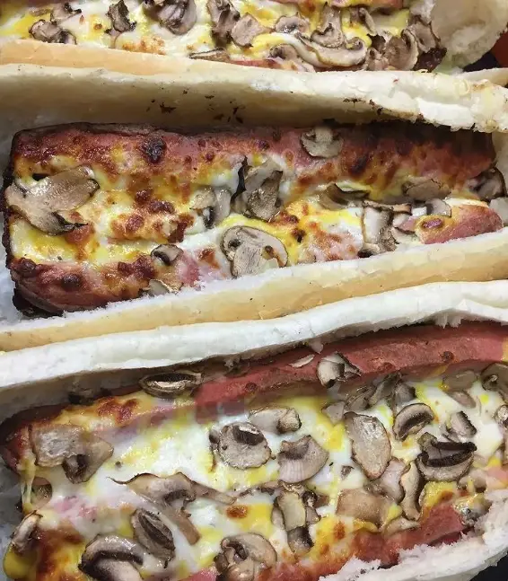 تصویر ساندویچ‌های پیتزایی مخصوص سبحانی با پنیر ذوب شده فراوان، قارچ و سوسیس مرغوب در نان باگت. بهترین انتخاب برای غذای فوری و خوشمزه.
