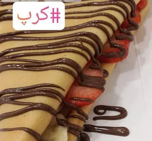 تصویری جذاب از کرپ‌های شکلاتی نوتلا کافه بستنی ایتالیایی نوتلالند، پرشده با توت‌فرنگی تازه و موز، دسری شیرین برای هر سلیقه.