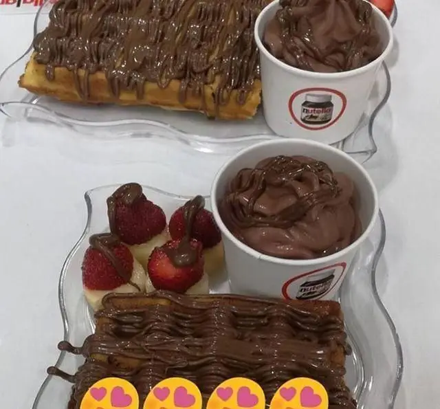 دو پرس دسر شکلاتی در کافه بستنی ایتالیایی نوتلالند: وافل‌های غرق در نوتلا، بستنی سافت سرو نوتلا و میوه.